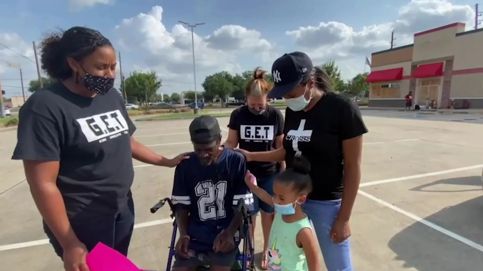 An outreach team praying with a man in a wheelchair